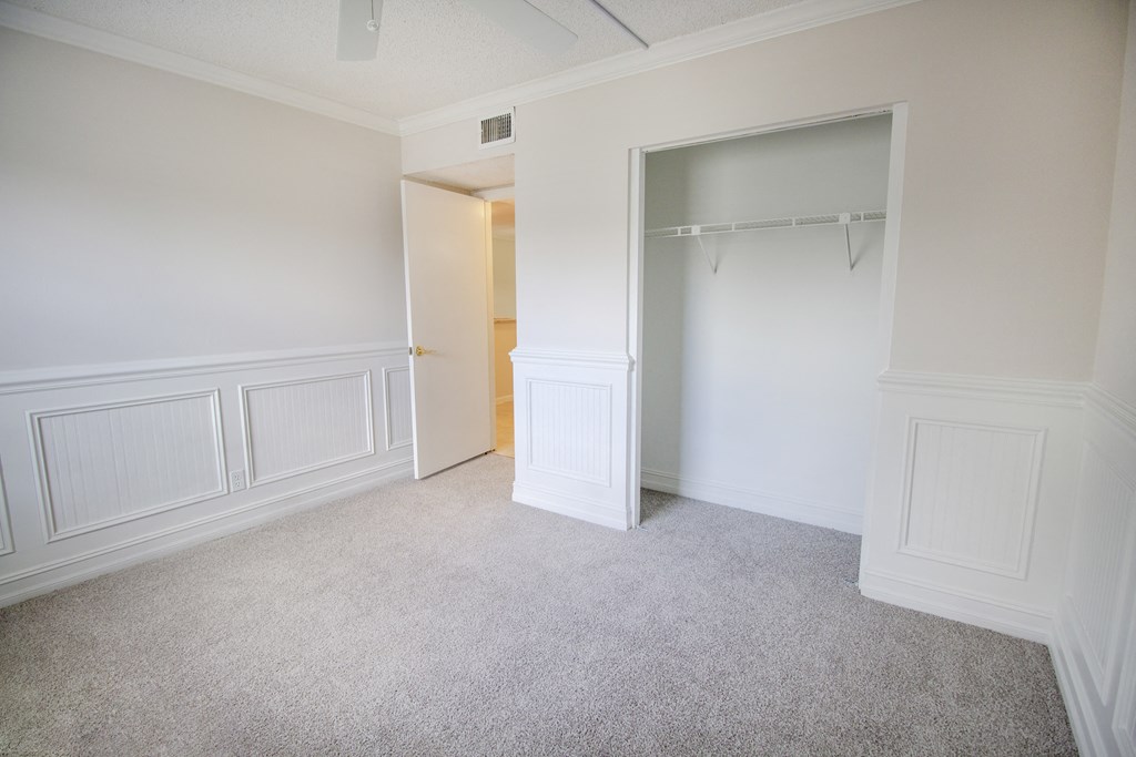 A room with a carpeted floor and a white door.